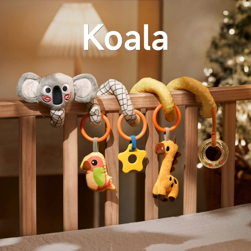 A koala-themed spiral baby toy attached to a crib, featuring a plush koala, parrot, star-shaped teether, giraffe, and bead rattle. The toy is designed to provide interactive fun and promote sensory development for babies.